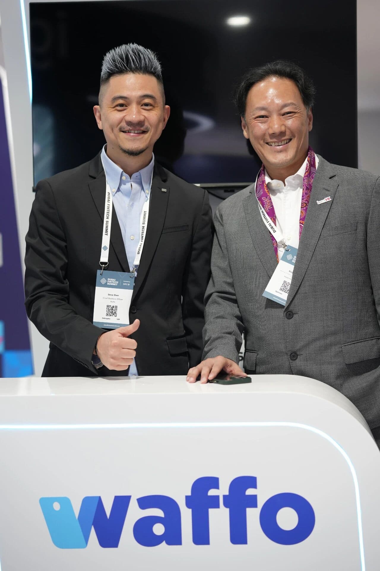 ドバイ・フィンテック・サミットのブースでサムズアップする Waffo 共同創業者 Steve Shen と InvestHK の King Leung 氏。