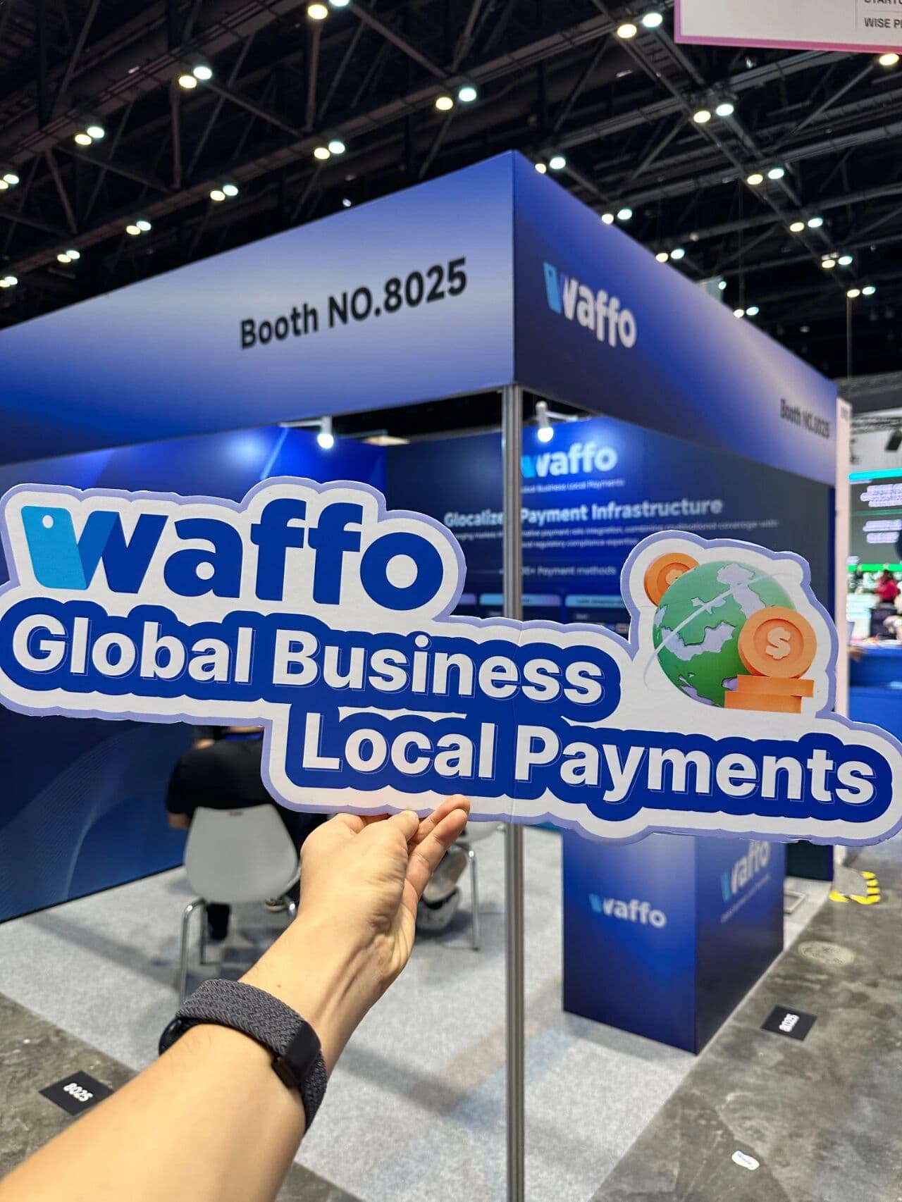 Close-up of Waffo's core value proposition sign reading "Global Business, Local Payments" held at the exhibition.